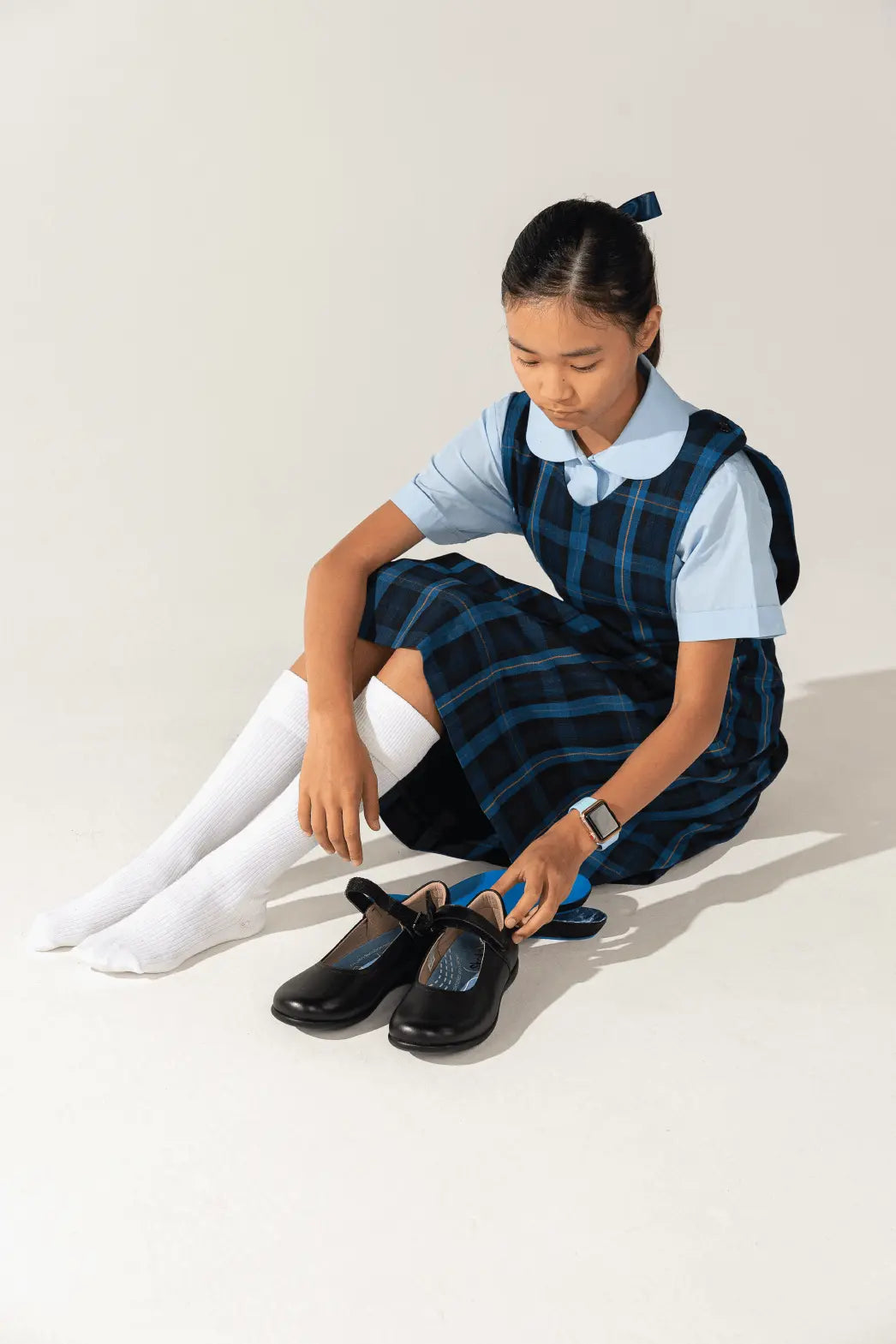 school girl sitting and putting on shoes